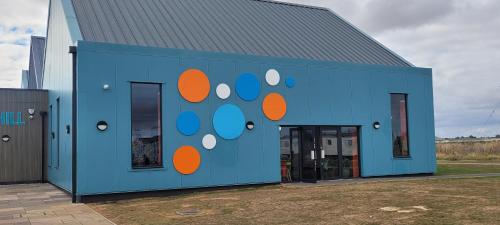 a blue building with a painting on the side of it at Willerby Delux - Holiday Home by the Sea - close to the Entertainment Complex-bedding, towels & wifi Included! in Jaywick Sands