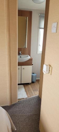 a bathroom with a sink and a mirror at Willerby Delux - Holiday Home by the Sea - close to the Entertainment Complex-bedding, towels & wifi Included! in Jaywick Sands
