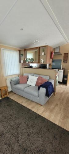 a living room with a couch and a kitchen at Willerby Delux - Holiday Home by the Sea - close to the Entertainment Complex-bedding, towels & wifi Included! in Jaywick Sands