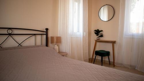 a bedroom with a bed and a mirror and a chair at Σπιτι στο κέντρο της πόλης in Mytilini
