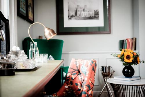 a desk with a chair and a table with a vase of flowers at The Queen's Head in Kingston upon Thames