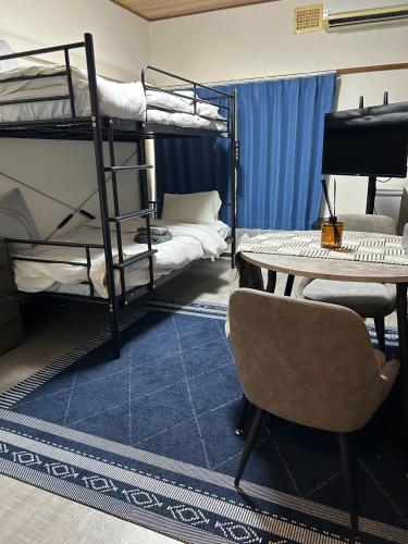 a room with bunk beds and a desk and a table at Sirius AMA - Vacation STAY 20068 in Tsukuba