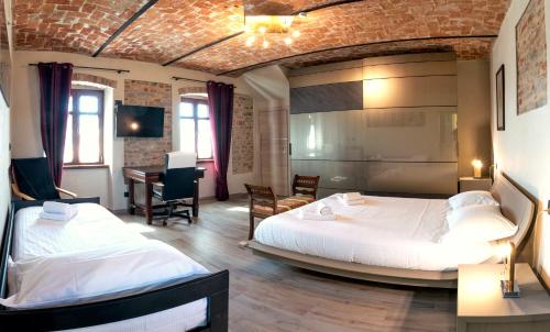 a bedroom with two beds and a desk in it at La Picchiera - Appartamento Silvio in La Morra