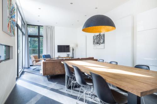a dining room with a large wooden table and chairs at Holiday Home Maridu Family L-Cube in Arnhem