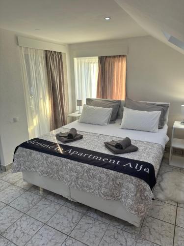 Un dormitorio con una cama grande con dos sombreros. en Apartman Alja, en Sombor