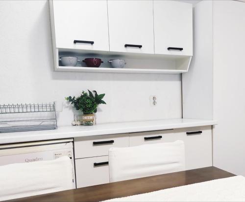 a white kitchen with white cabinets and a mirror at Ana's Garden House in Ohrid