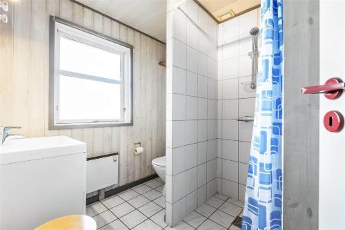 a bathroom with a toilet and a sink and a window at 0074-Romo-Lakolk-174 in Lakolk
