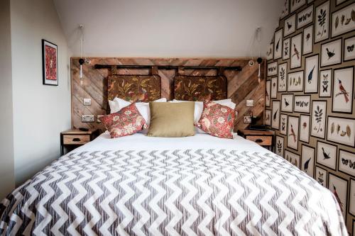 a bedroom with a large bed with a wooden headboard at The Queen's Head in Kingston upon Thames