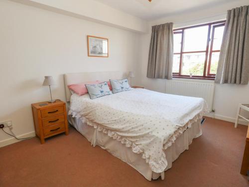 a bedroom with a white bed with blue pillows at Flat 9 in Swanage