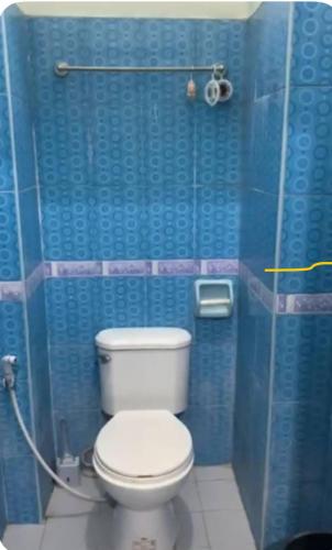 トゥゲガラオ・シティにあるGSB City Apartelleのバスルーム(青い屋台の白いトイレ付)