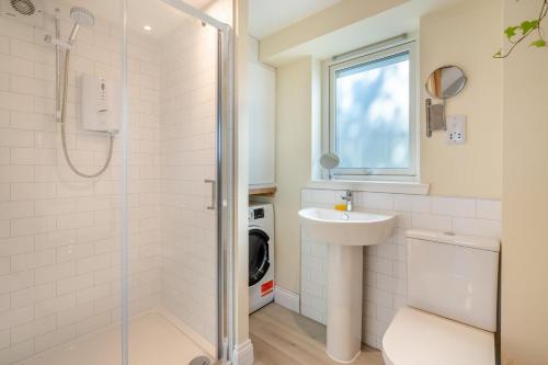 a bathroom with a shower and a sink and a washing machine at Wash House - Tayport in Dundee