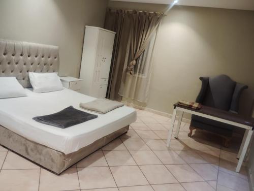 a bedroom with a bed and a table and a chair at لؤلؤة الرياض in Riyadh
