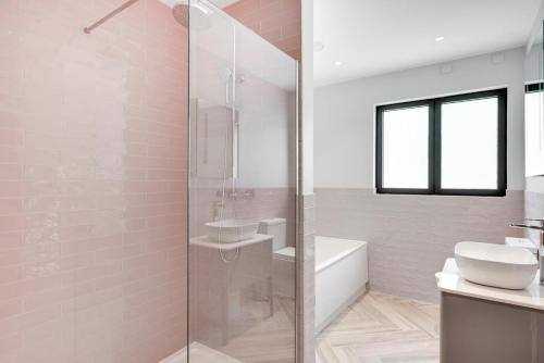 a bathroom with a glass shower and a sink at Daisys Barn in Mattishall