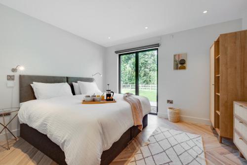 a bedroom with a large bed and a large window at Daisys Barn in Mattishall
