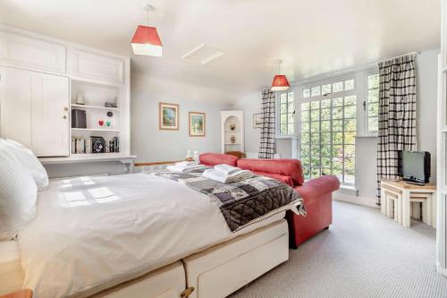 - une chambre avec un grand lit et deux chaises rouges dans l'établissement Coach House Cottage Annexe, à Wickham Market