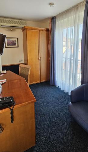 a hotel room with a desk and a window at Hotel Ochsen Stuttgart in Stuttgart