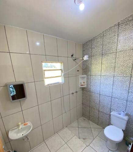 a bathroom with a toilet and a sink at Espaço Encantado STL in São Thomé das Letras