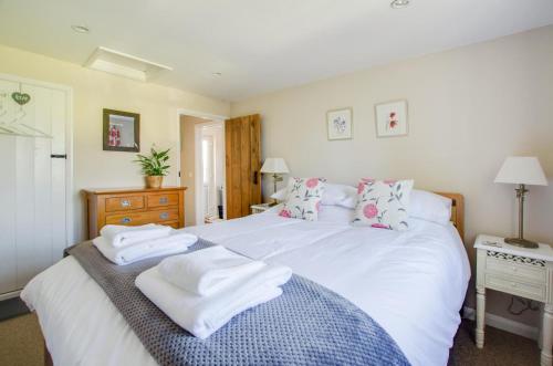 a bedroom with a large white bed with towels on it at Larksfield Snug in Debach