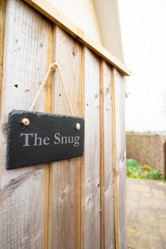 a sign on the side of a wooden fence at Larksfield Snug in Debach