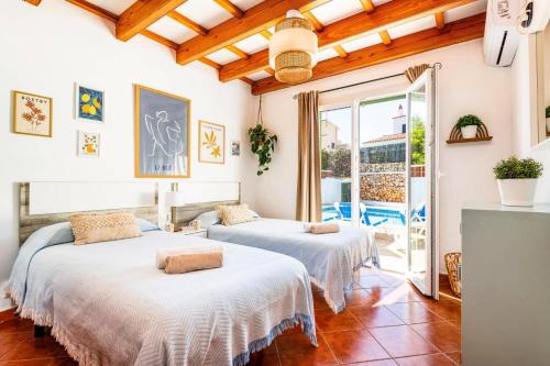 two beds in a room with a balcony at Villa De La Luz by Villa Plus in Punta Prima