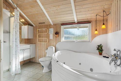 a bathroom with a white tub and a toilet at FAN028-Fano-Strandgardsvej-2 in Fanø