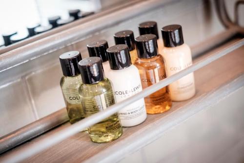 a shelf with four bottles of perfume on it at The Queen's Head in Kingston upon Thames