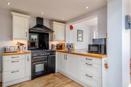 a kitchen with white cabinets and black appliances at Mill Cove in Wrentham