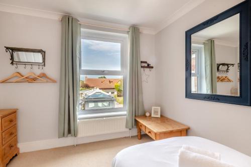 a bedroom with a bed and a mirror and a table at Mill Cove in Wrentham