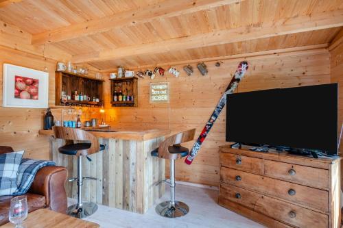 a log cabin with a bar and a tv in it at Mill Cove in Wrentham
