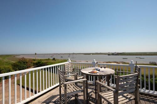 a table and chairs on a balcony with a view of the ocean at The Pavilion in Orford