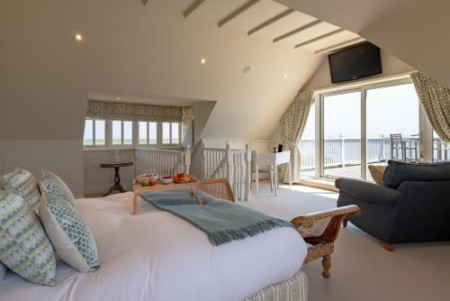 a bedroom with a large white bed and a living room at The Pavilion in Orford