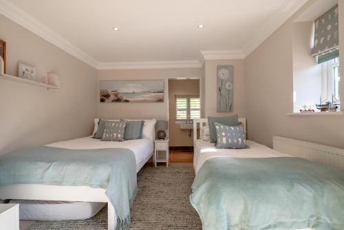two beds sitting in a room withermottermottermottermott at The Pavilion in Orford
