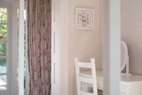 a white room with a chair and a window at The Pavilion in Orford