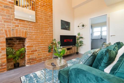 カンタベリーにあるUnique Rooftop Retreat - City View - Sleeps 4のソファとレンガの壁のあるリビングルーム