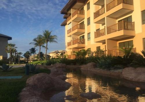 a building with a pond in front of a building at VG Sun Cumbuco - Praia e Tranquilidade in Caucaia