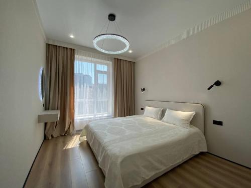 Un dormitorio con una cama y una ventana grande. en Luxury Apartament, en Astana