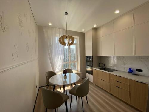 Una cocina con mesa y sillas y una ventana. en Luxury Apartament, en Astana