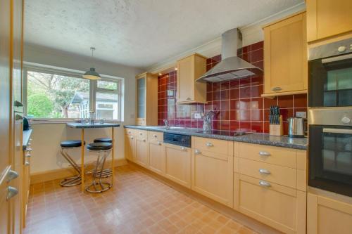 a large kitchen with wooden cabinets and a window at Fallowfield in Reydon