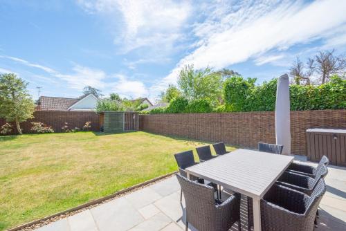 a patio with a table and chairs and a yard at Loxwood in Reydon