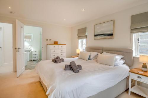 a bedroom with a large white bed with two towels on it at Pembroke Cottage in Walberswick