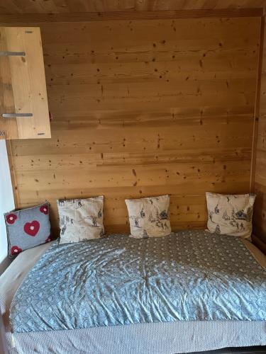 a bedroom with a bed with a wooden wall at standing 4 étoiles in Demi-Quartier