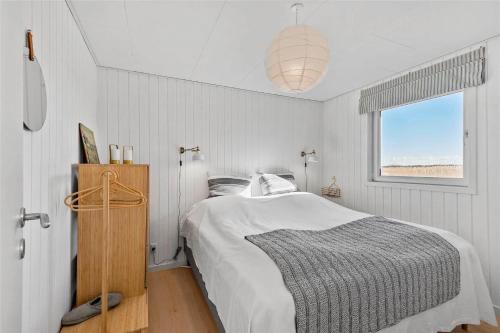 a white bedroom with a bed and a window at 0035-Romo-Lakolk-39 in Lakolk