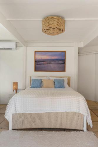a bedroom with a large white bed with blue pillows at FlowHouse Jeri - Hotel & Coworking in Jericoacoara
