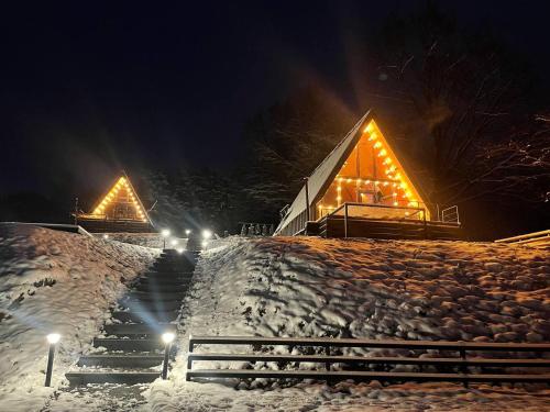 a house with lights on it in the snow at night at Lav inn Polyana Затишок in Polyana
