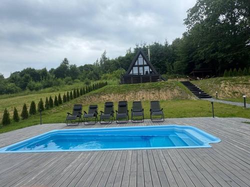 a swimming pool with chairs and a house at Lav inn Polyana Затишок in Polyana