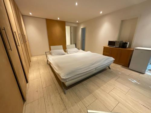 una camera da letto con un letto grande con lenzuola bianche di Ferienhaus im Odenwald a Modautal