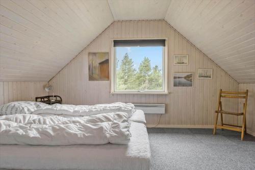 a attic bedroom with two beds and a window at 2601-Romo-Praestekraven-7 in Mølby