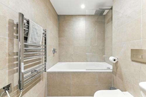 a bathroom with a tub and a toilet and a sink at Springfield Two in Harrogate