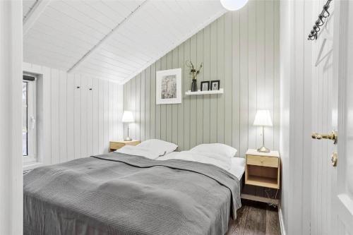 a white bedroom with a bed and two lamps at 0155-Romo-Davidstraede-10-c in Kongsmark