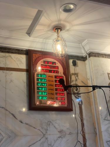 a chandelier hangs above a poker board on a wall at Ghazala Beautiful Hotel shuttle service to the Haram in Mecca